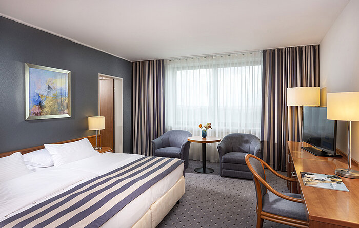 Familienzimmer im Maritim Hotel Ulm mit Doppelbett, Schreibtisch, Sitzecke und viel Tageslicht