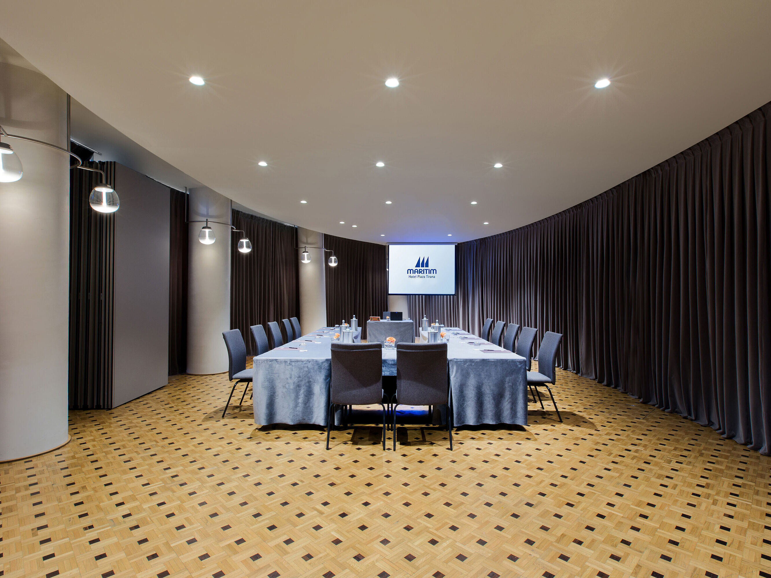 Moderner Tagungsraum im Maritim Hotel Plaza Tirana mit U-Bestuhlung, Leinwand und elegantem Vorhangdesign
