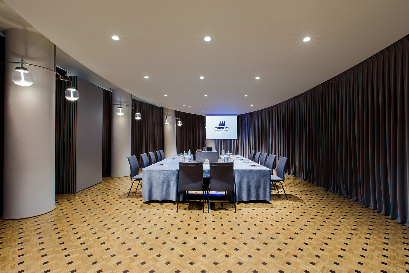 Moderner Tagungsraum im Maritim Hotel Plaza Tirana mit U-Bestuhlung, Leinwand und elegantem Vorhangdesign