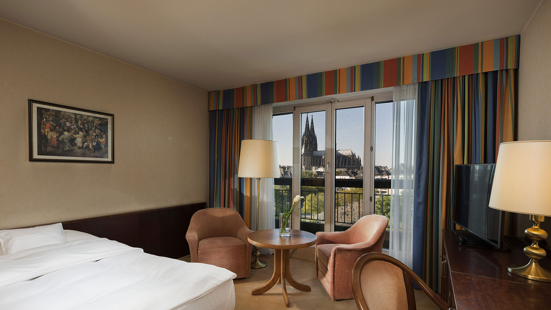 Superior-Zimmer im Maritim Hotel Köln mit Sitzbereich, komfortablem Bett und Blick auf den Kölner Dom.