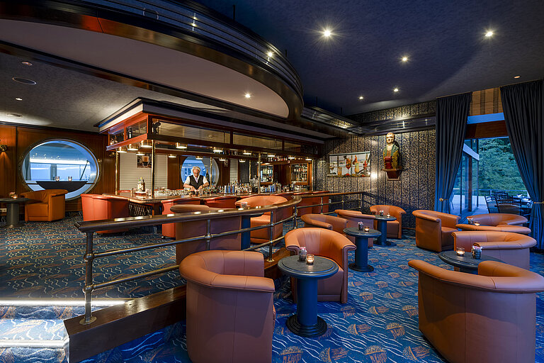 Stilvolle Bar mit gemütlichen Sesseln und maritimer Dekoration im Maritim Seehotel Timmendorfer Strand.
