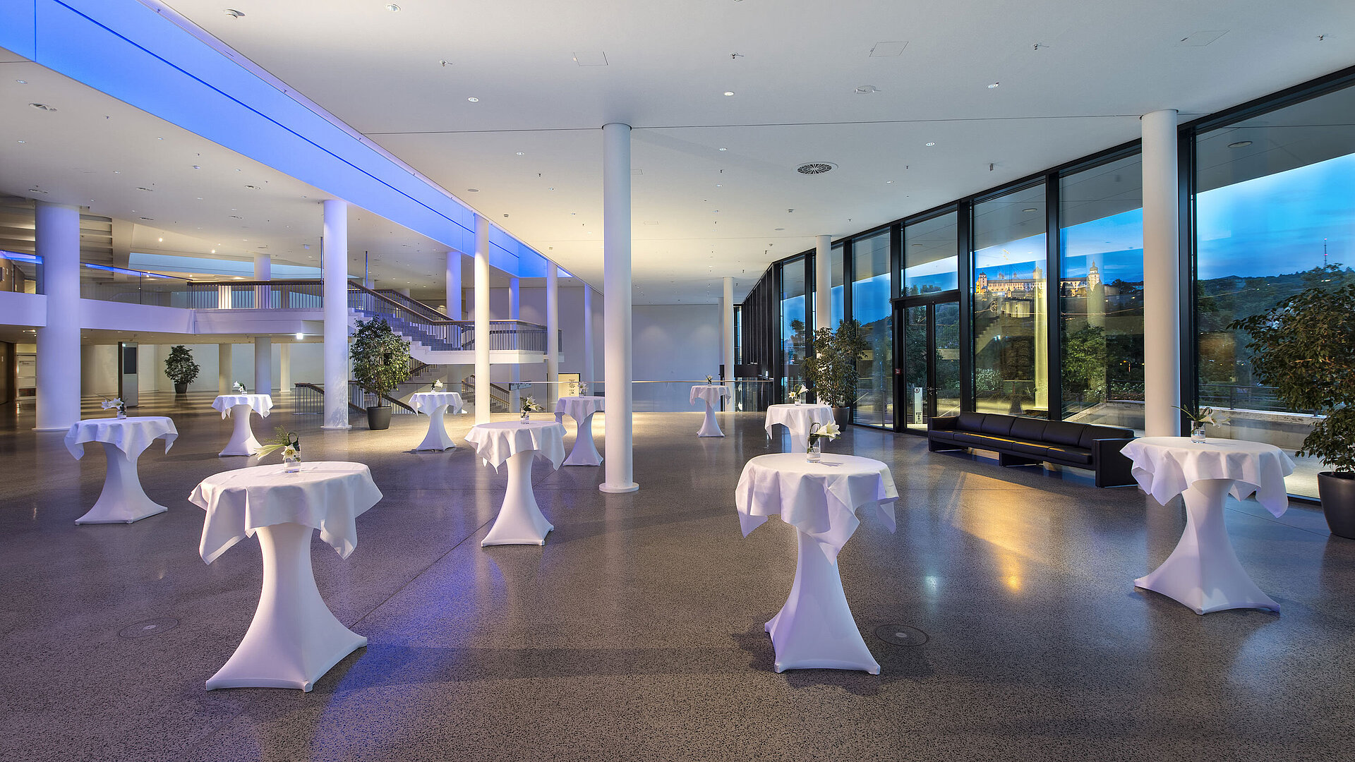 Modernes Foyer im Maritim Hotel Würzburg mit Stehtischen, großer Fensterfront und Blick auf die Festung