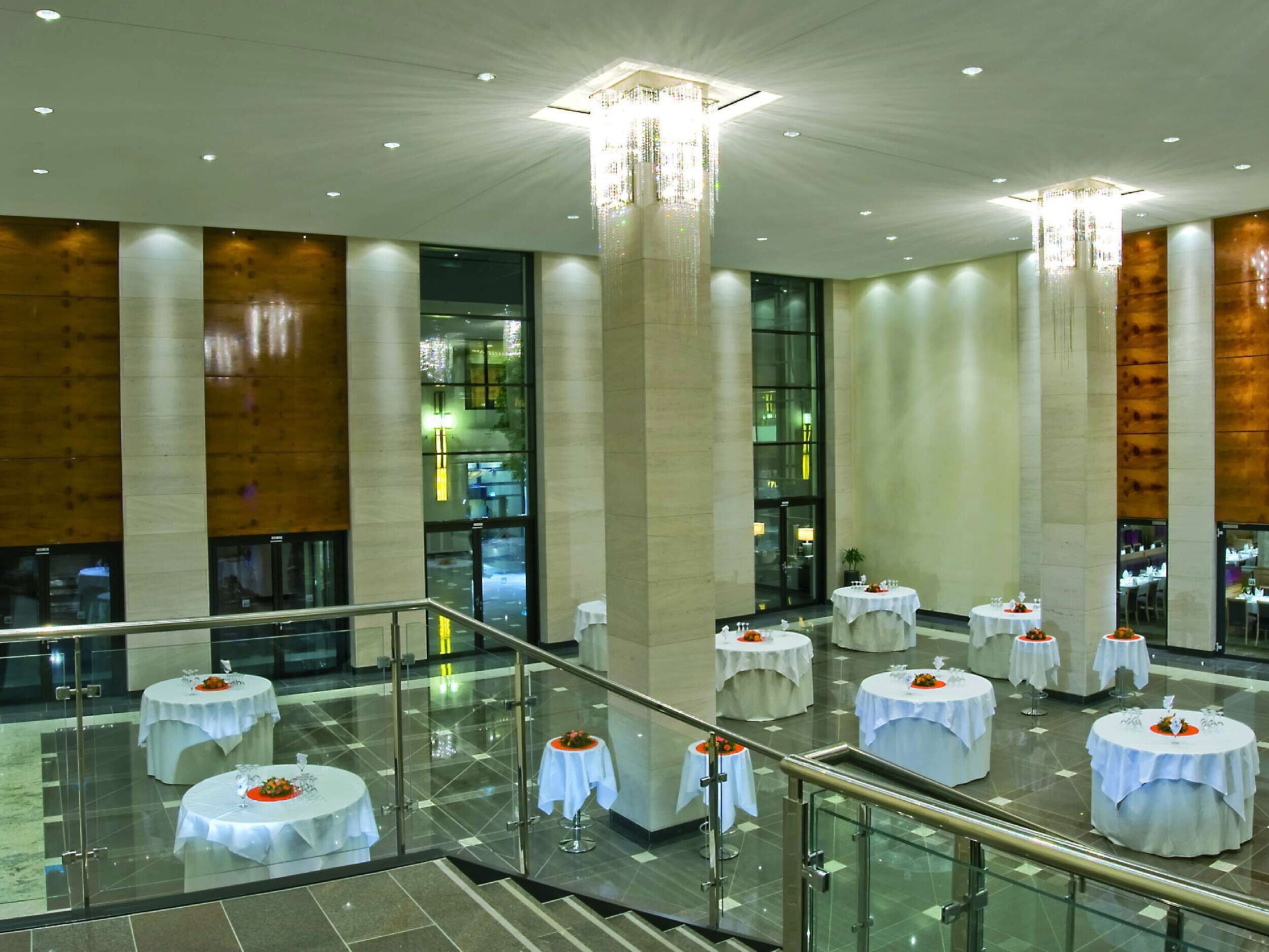 Elegantes Saalfoyer im Maritim Hotel Düsseldorf mit hohen Decken, stilvoll gedeckten Stehtischen und moderner Beleuchtung.