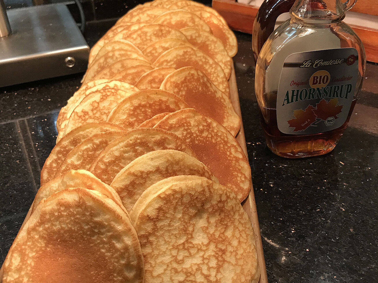 Frisch zubereitete Pancakes am Buffet, serviert mit Ahornsirup.