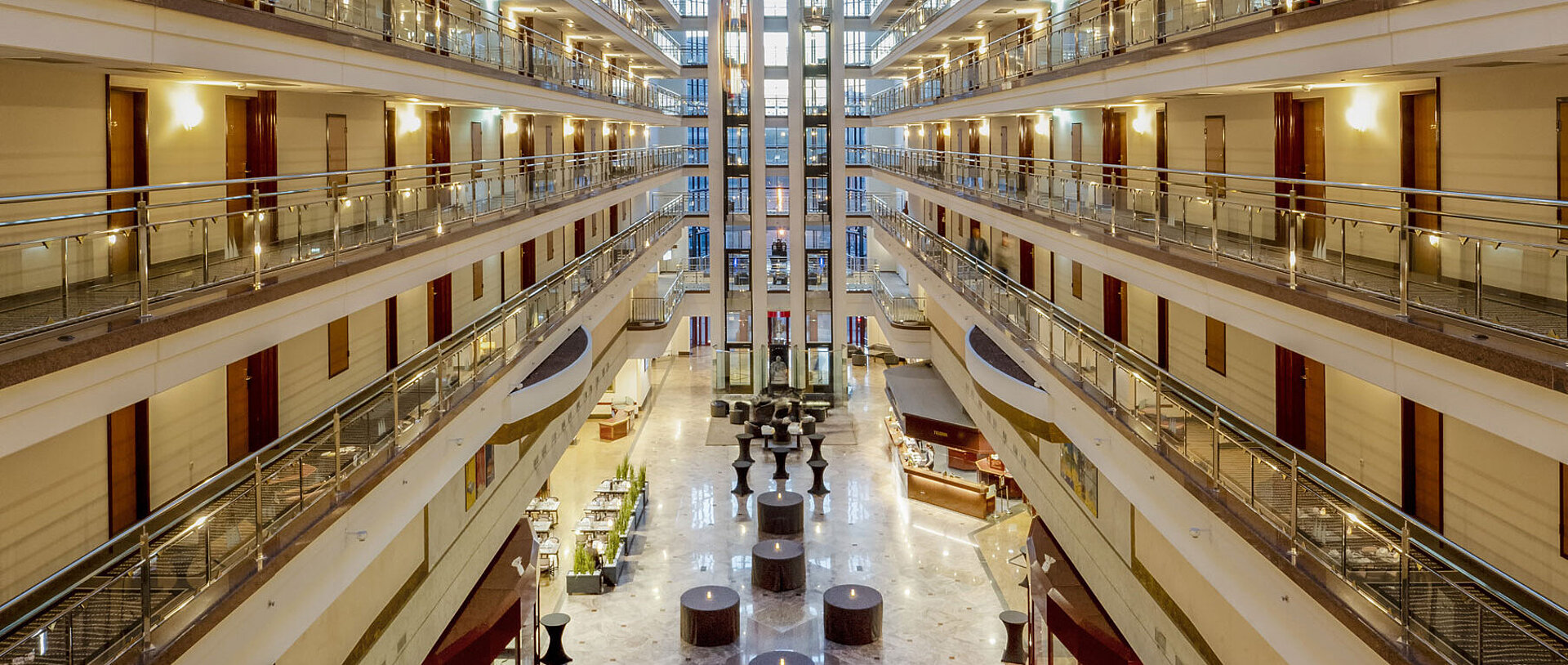 Lobby Beeindruckende Hotellobby mit Glasdach, mehreren Etagen und Sitzbereichen, die ein großzügiges und elegantes Ambiente schaffen.