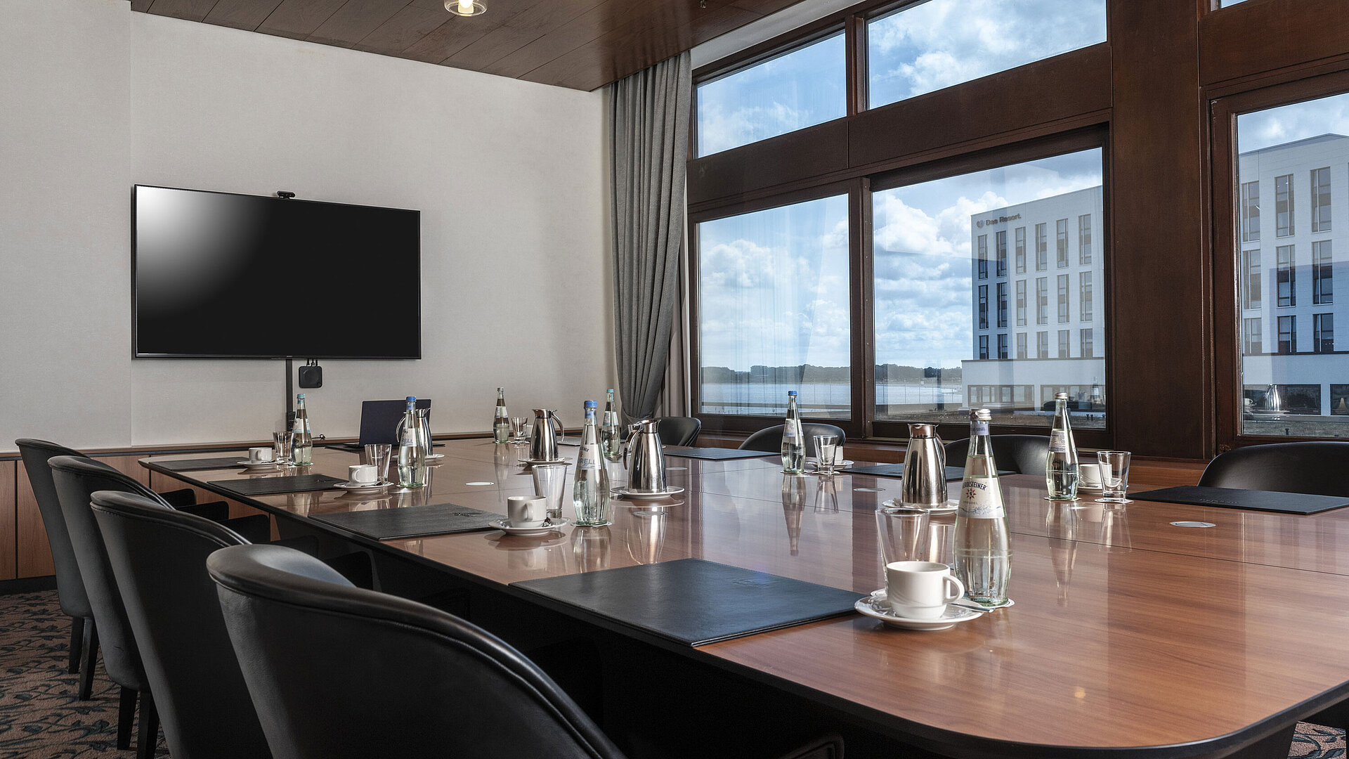 Moderner Konferenzraum mit großem Tisch, Seeblick und Technik im Maritim Hotel Travemünde