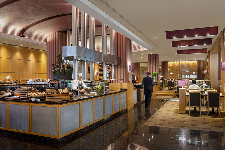 Frühstücksbereich im Maritim Hotel Düsseldorf mit Live-Cooking-Station, frischen Backwaren und eleganter Einrichtung.
