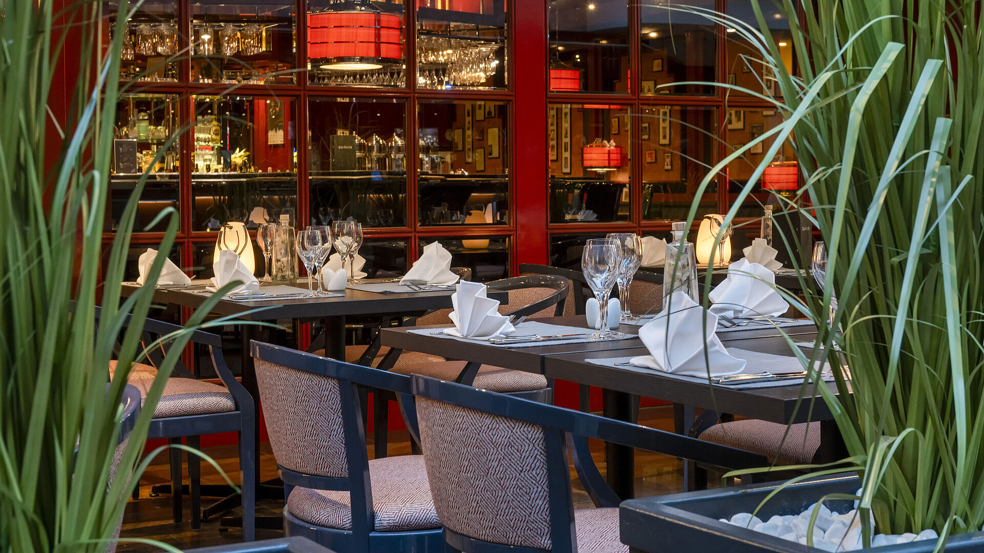 Stilvoll gedecktes Bistro im Maritim Hotel Magdeburg mit freundlicher Mitarbeiterin, die Tische vorbereitet.