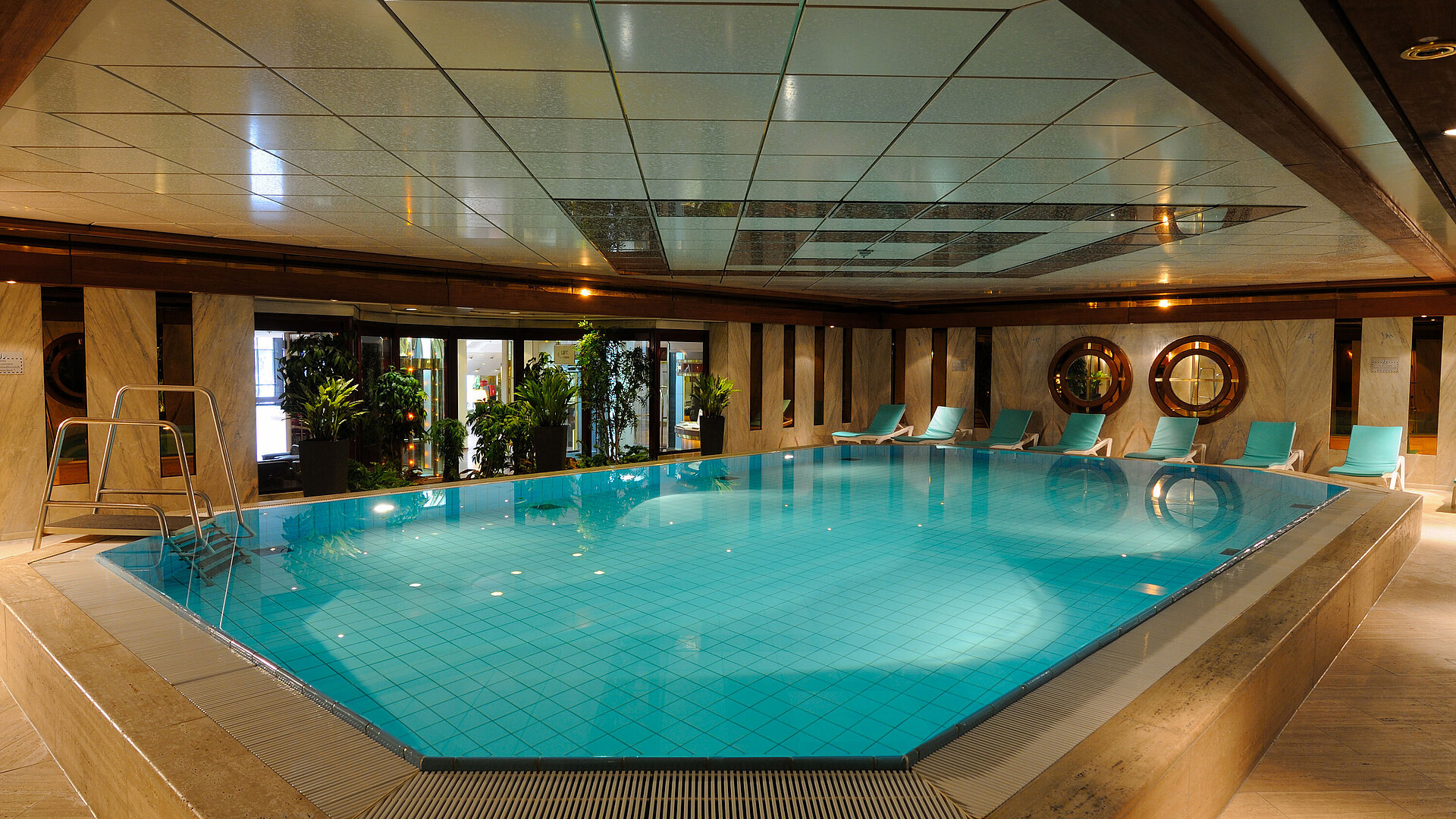 Schwimmbad Innenpool im Maritim Hotel Köln mit Liegestühlen und Pflanzen für eine entspannende Atmosphäre.