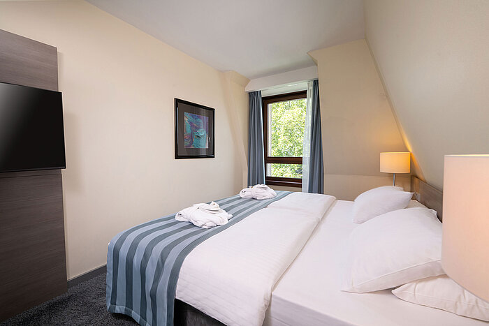 Junior Suite Schlafzimmer der Junior Suite im Maritim Hotel Königswinter mit Doppelbett, Fenster und hellem Ambiente.