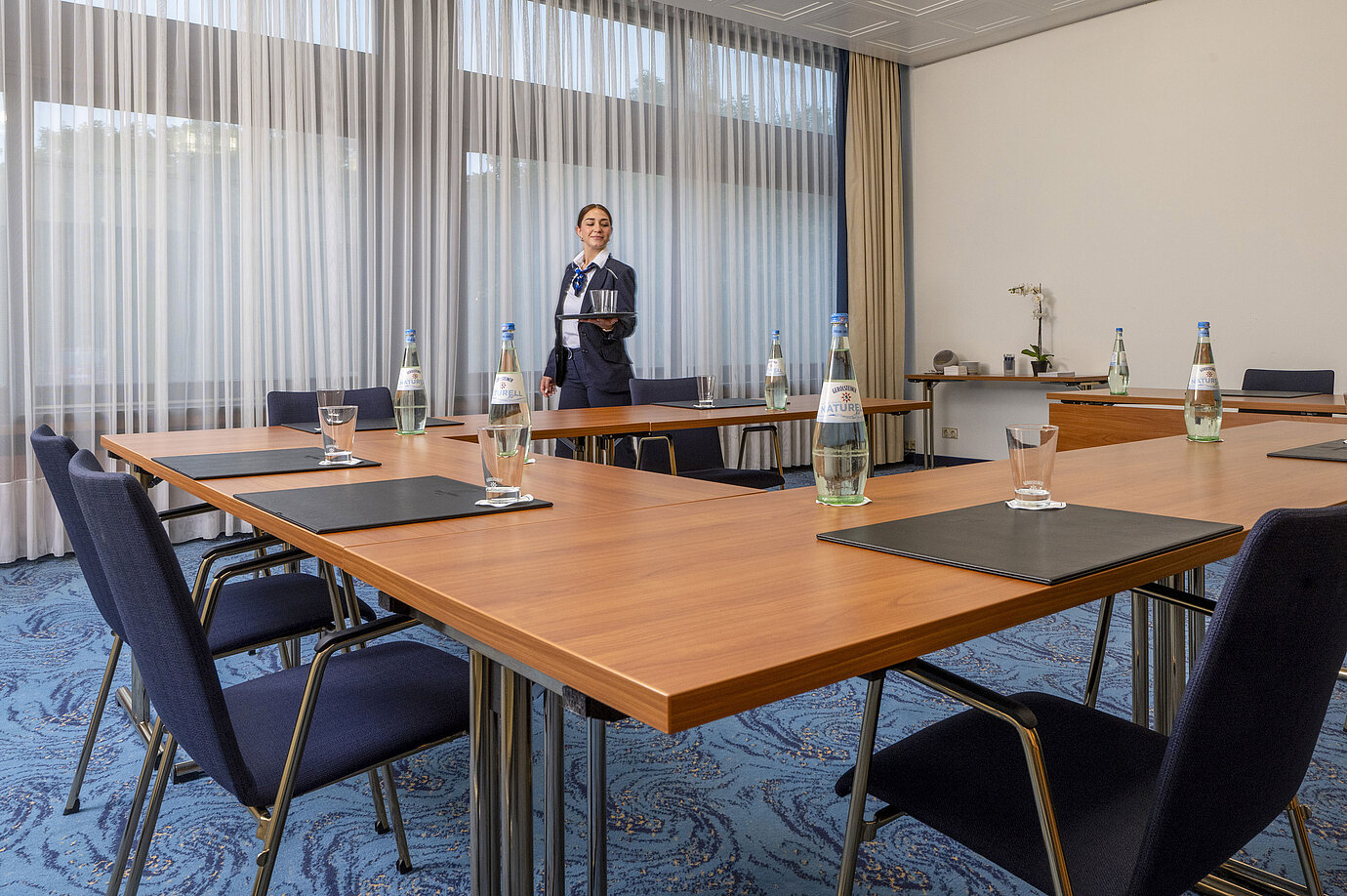 Tagungsraum mit U-Bestuhlung und freundlicher Maritim-Mitarbeiterin im Maritim Hotel Travemünde