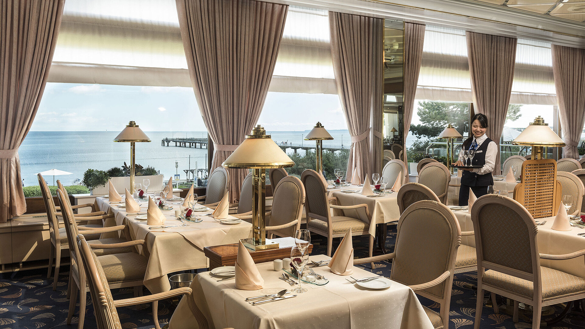 Seeterrassen-Restaurant mit Ostseeblick Elegantes Restaurant mit Meerblick und gedeckten Tischen im Maritim Seehotel Timmendorfer Strand.