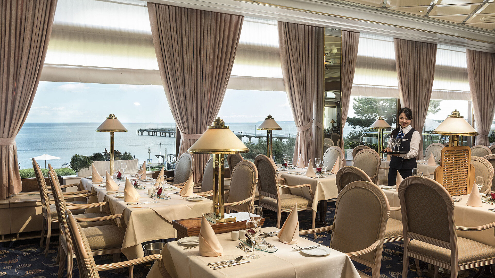 Elegantes Restaurant mit Meerblick und gedeckten Tischen im Maritim Seehotel Timmendorfer Strand.
