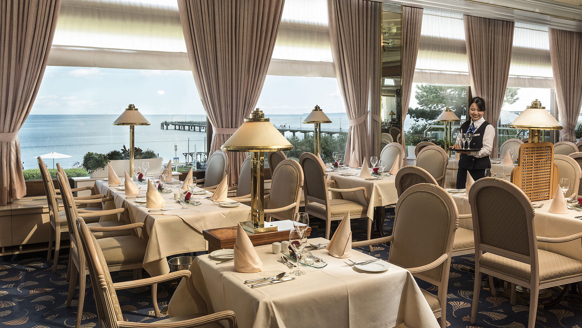 Elegantes Restaurant mit Meerblick und gedeckten Tischen im Maritim Seehotel Timmendorfer Strand.