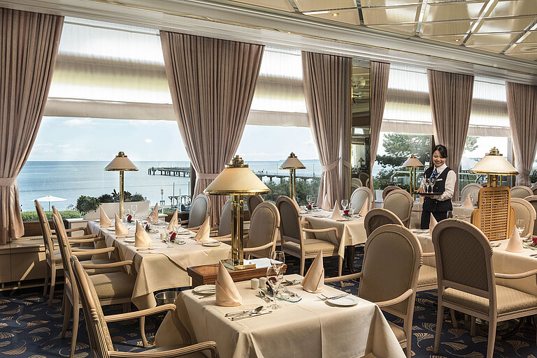 Elegantes Restaurant mit Meerblick und gedeckten Tischen im Maritim Seehotel Timmendorfer Strand.