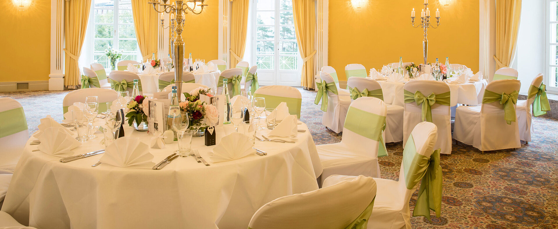 Fürst-Karl-Kuppelsaal Festlich gedeckter Saal mit weißen Hussen und grünen Schleifen für Hochzeiten im Maritim Hotel Bad Wildungen