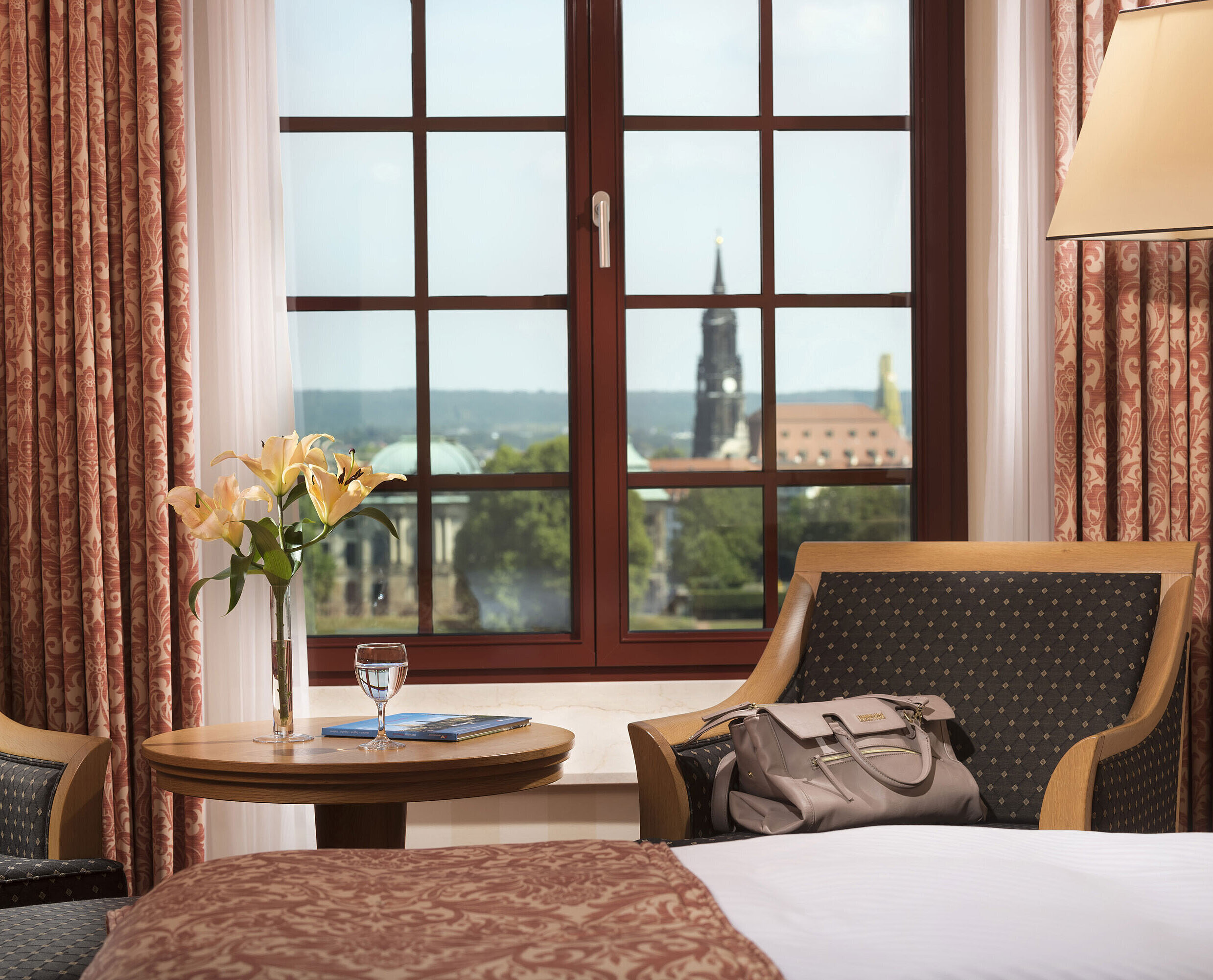 Sitzbereich im Superior Zimmer des Maritim Hotel Dresden mit Blick aus dem Fenster auf die historische Altstadt.