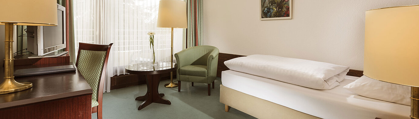Comfort Zimmer Freundliches Einzelzimmer mit Sessel, Schreibtisch und großem Fenster im Maritim Hotel Bad Salzuflen