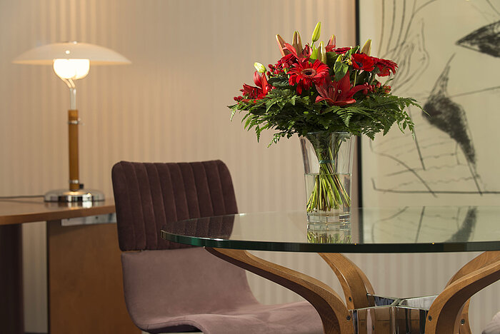 Eleganter Blumenstrauß auf einem Glastisch in der Präsidenten-Suite des Maritim proArte Hotel Berlin.