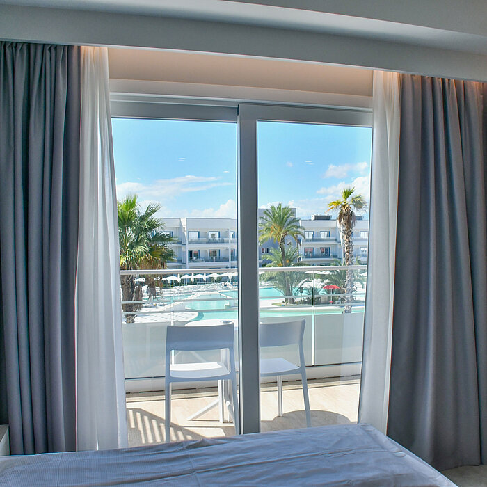 Blick vom Hotelzimmerbalkon im Maritim Resort Calabria auf Pool, Palmen und Hotelanlage