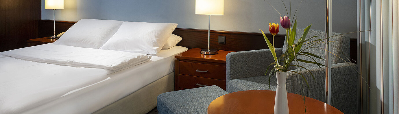 Komfortables Einzelzimmer mit Queensize-Bett, modernen Möbeln und stimmungsvollem Licht im Maritim Hotel Darmstadt.