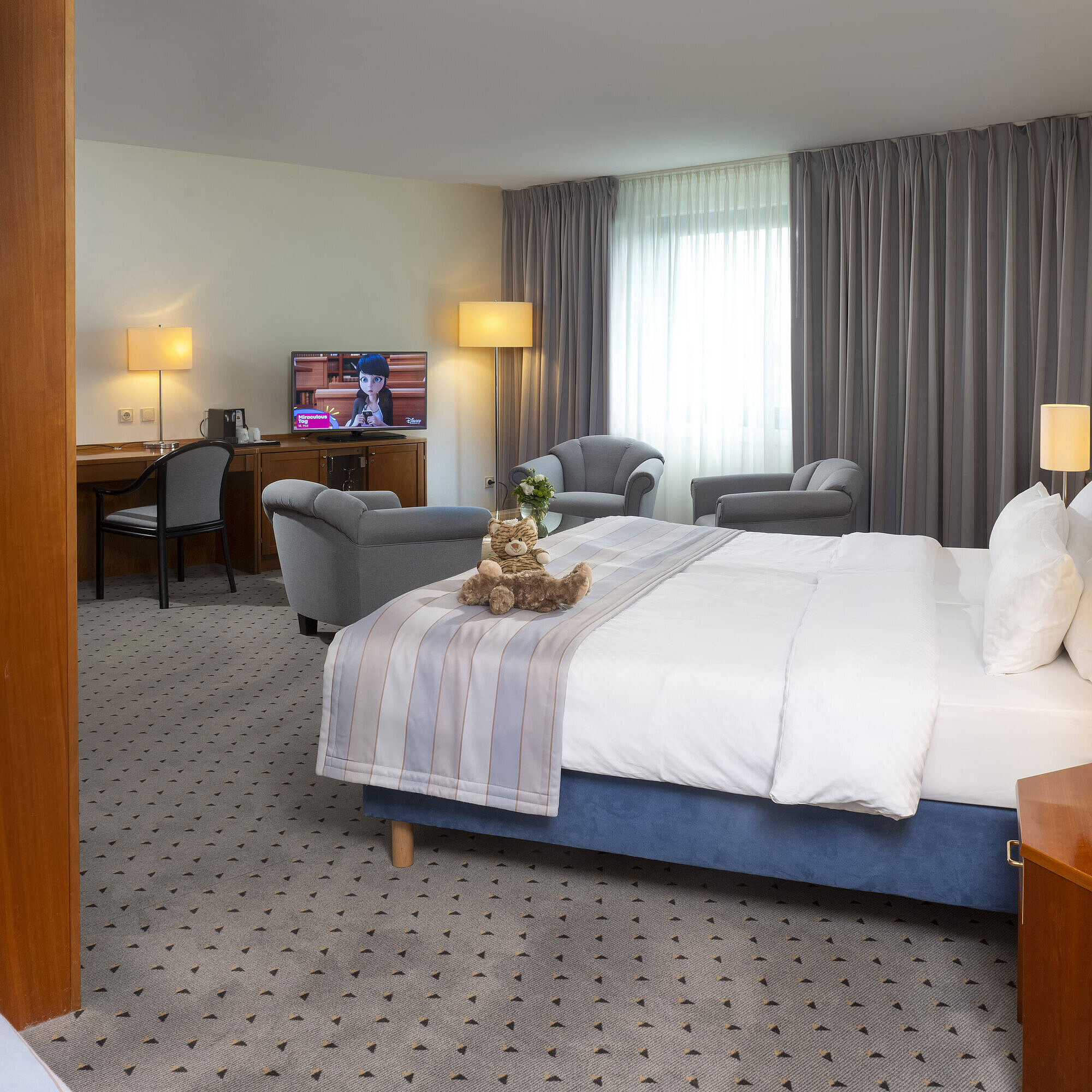 Superior Familienzimmer Geräumiges Zimmer im Maritim Hotel Hannover mit Doppelbett, Sitzbereich und TV.