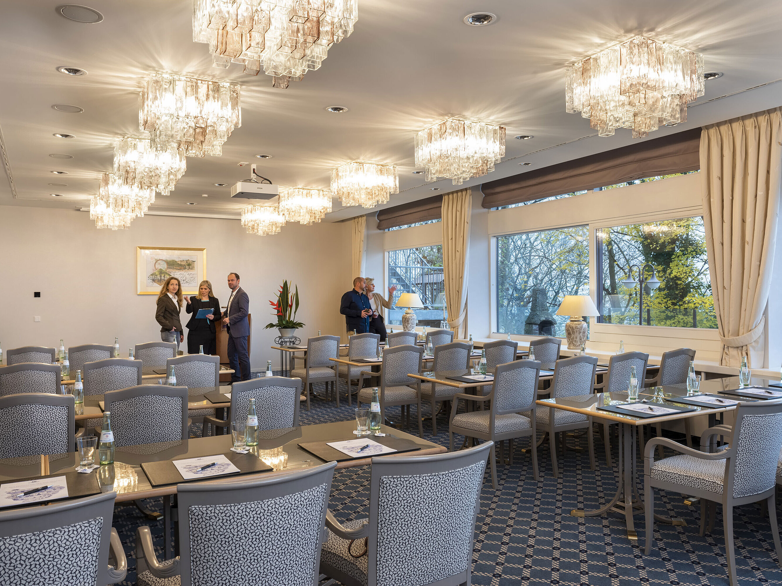 Der Salon Kopenhagen im Maritim Hotel Kiel, ein eleganter Konferenzraum mit Kronleuchtern, gedeckten Tischen und großen Fenstern.