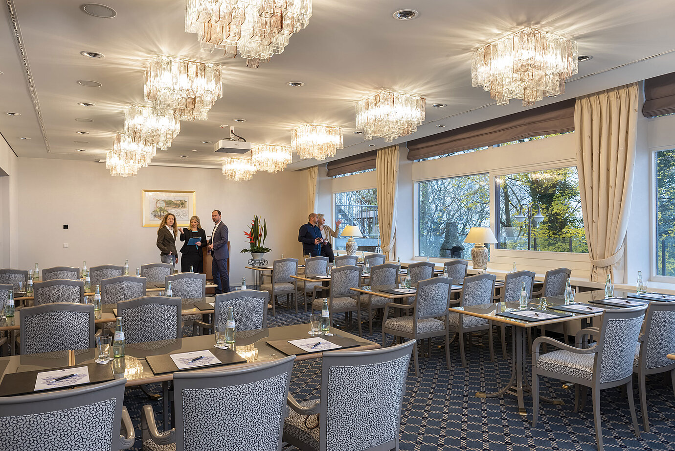 Der Salon Kopenhagen im Maritim Hotel Kiel, ein eleganter Konferenzraum mit Kronleuchtern, gedeckten Tischen und großen Fenstern.