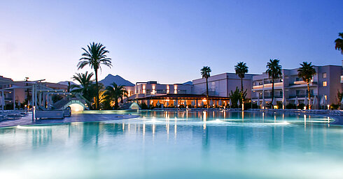 Poolbeleuchtung am Abend im Maritim Resort Calabria mit Palmen und Gebirgskulisse