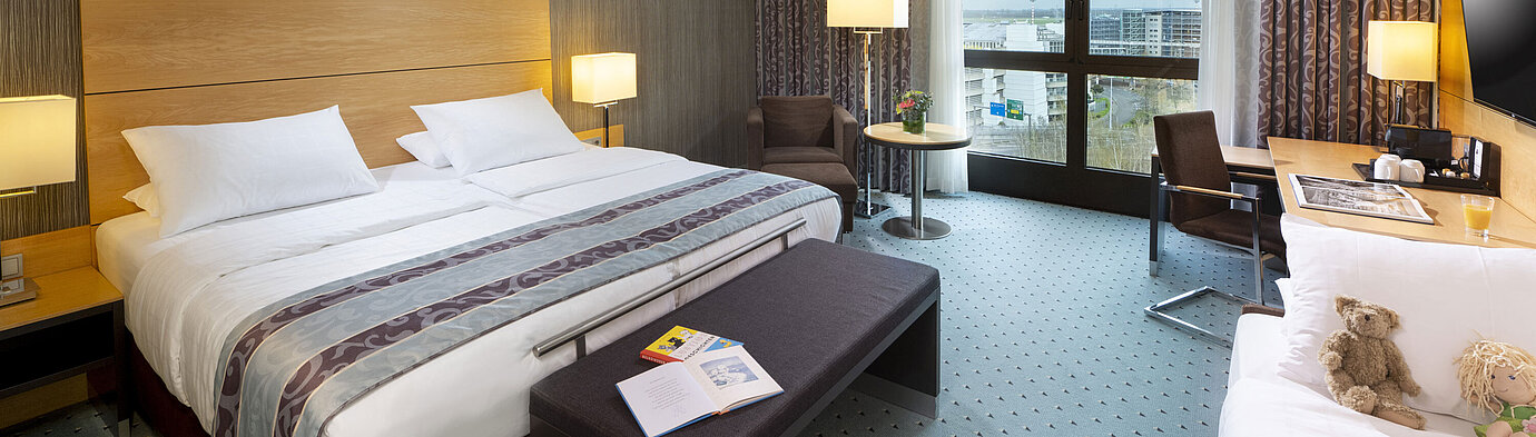 Geräumiges Superior Familienzimmer im Maritim Hotel Düsseldorf mit großem Bett, Zusatzbett und Blick auf die Stadt.