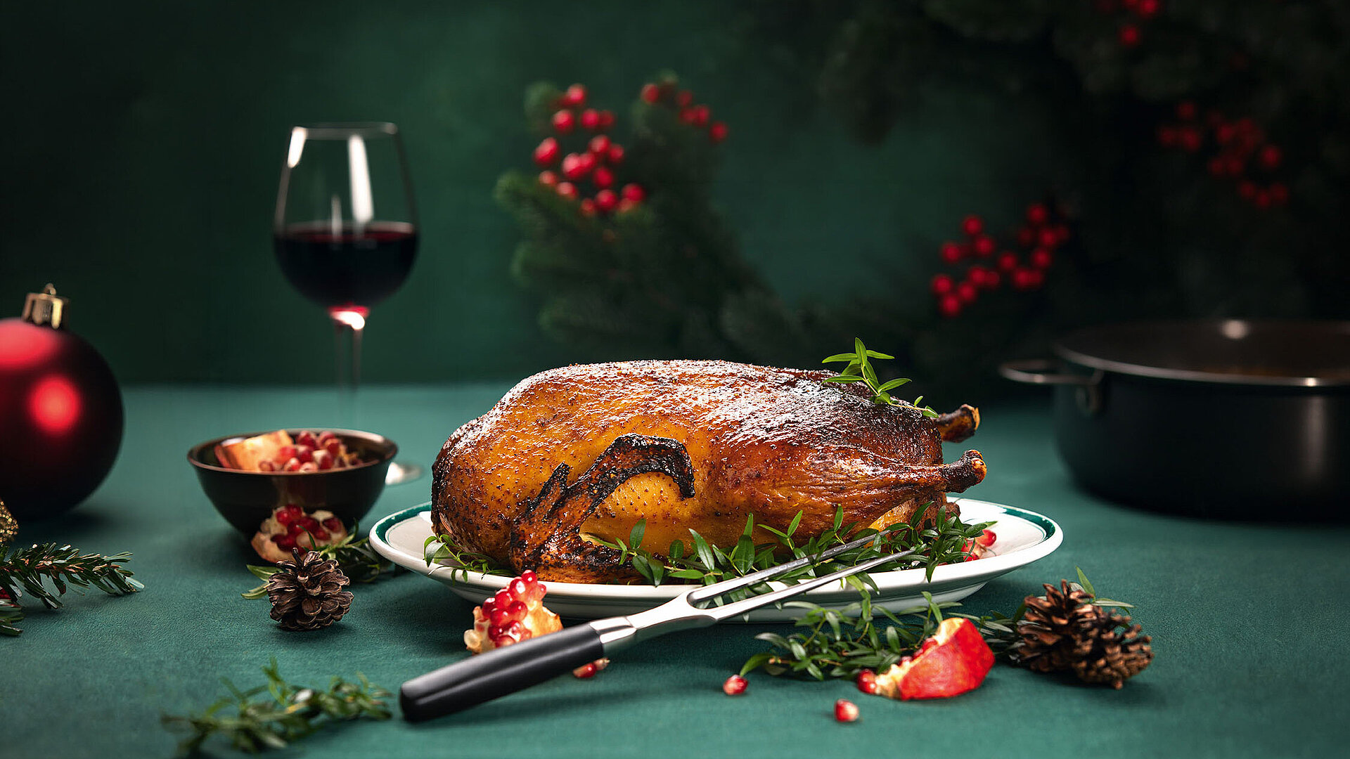 Festlicher Gänsebraten mit Rotwein und weihnachtlicher Tischdekoration