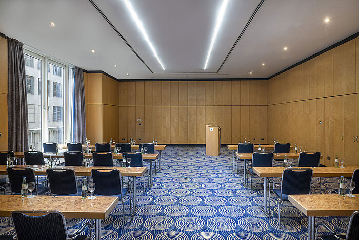 Tagungsraum Salon IV im Maritim proArte Hotel Berlin mit Tischen, Stühlen und Rednerpult.