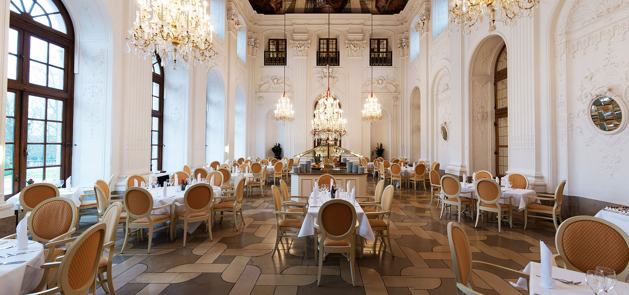 Eleganter Apollo Saal im Maritim Hotel Fulda mit Kronleuchtern, Freskendecke und stilvoll gedeckten Tischen.