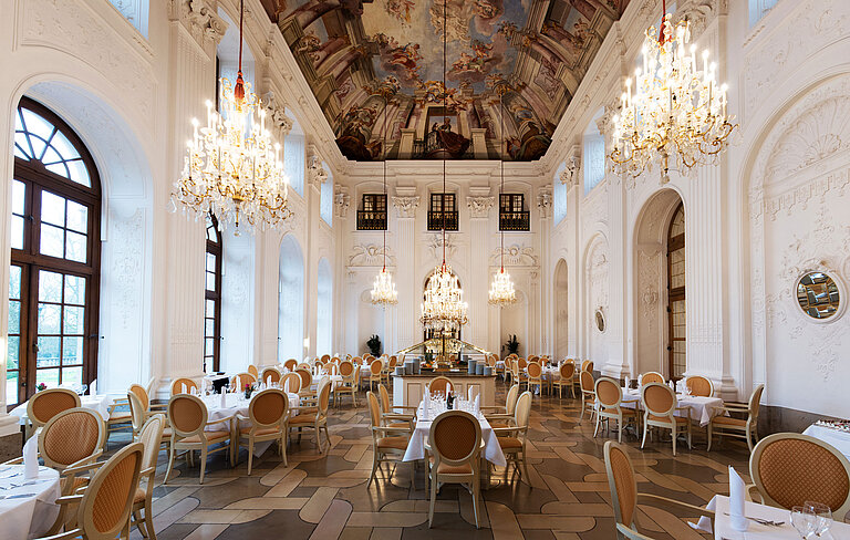 Eleganter Apollo Saal im Maritim Hotel Fulda mit Kronleuchtern, Freskendecke und stilvoll gedeckten Tischen.