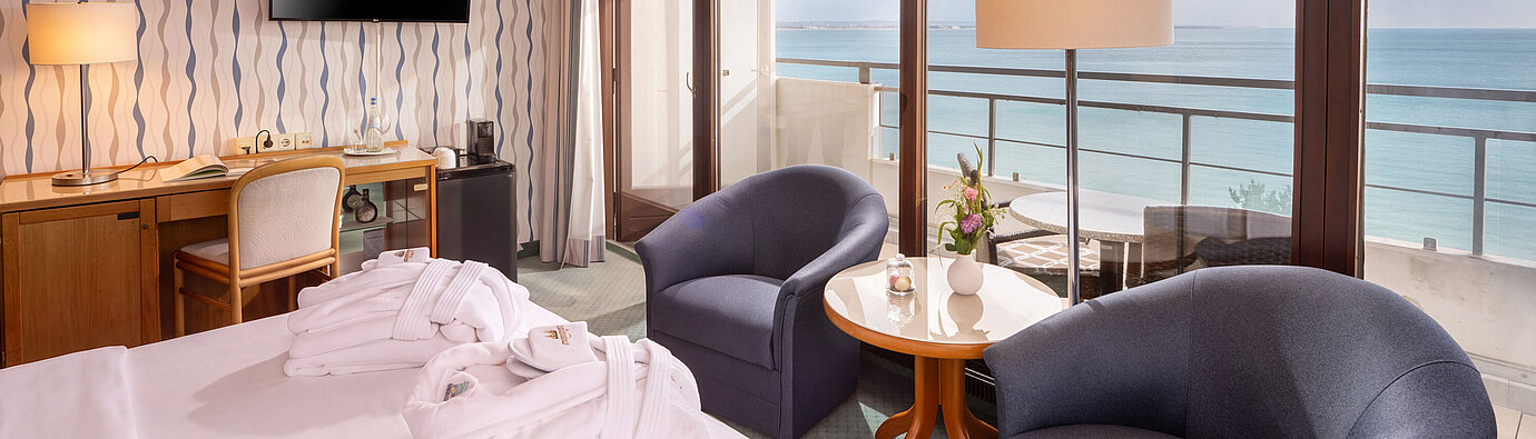 SuperiorPlus Zimmer Seeseite mit Sitzecke, Doppelbett und Balkon mit Blick auf die Ostsee