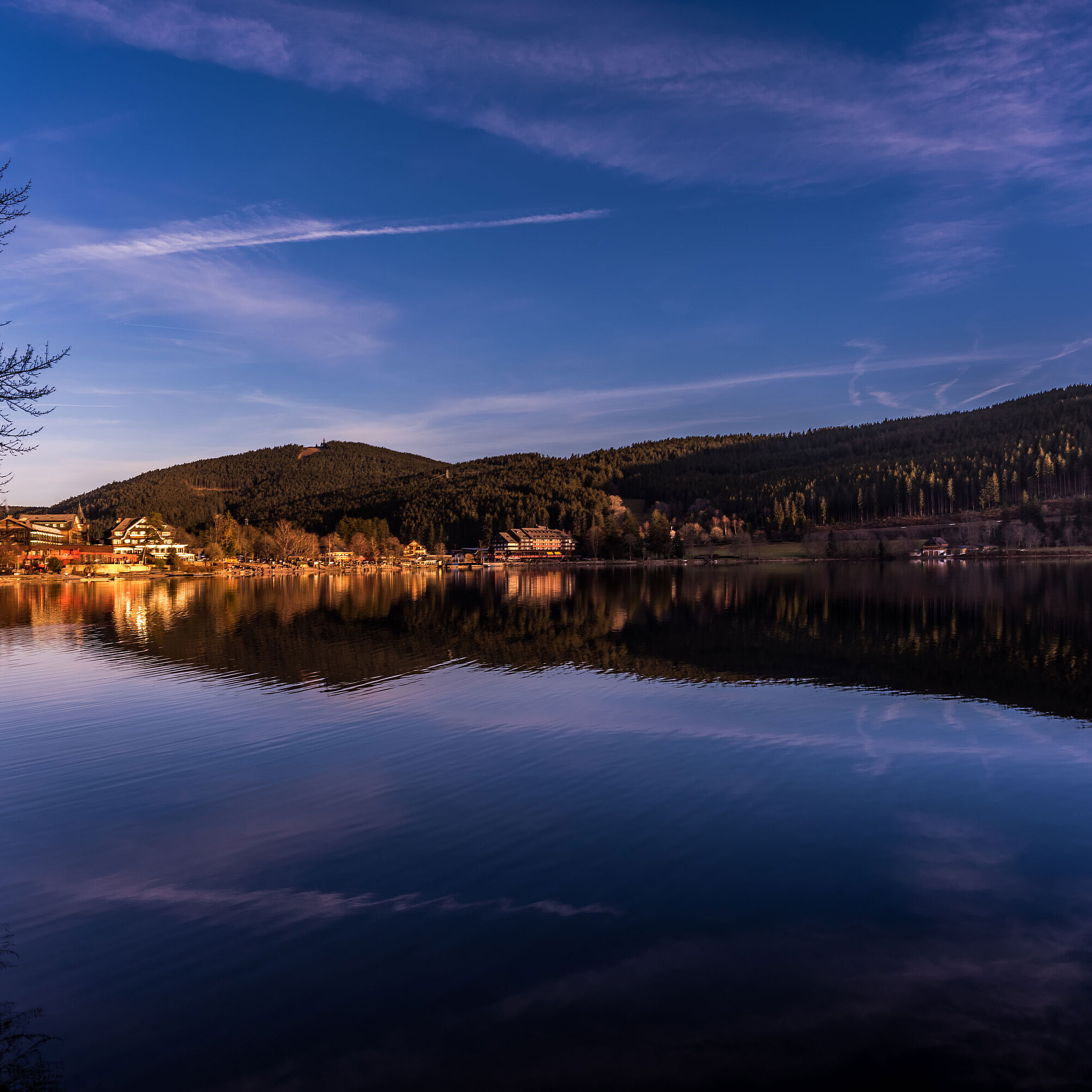 Blick auf den Titisee bei Sonnenuntergang mit Spiegelung des Maritim Hotels im Wasser