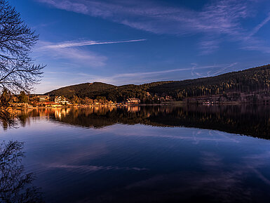 Blick auf den Titisee bei Sonnenuntergang mit Spiegelung des Maritim Hotels im Wasser