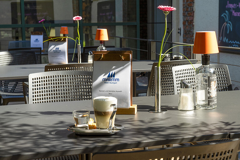 Cappuccino, Wasser und Gebäck auf der sonnigen Terrasse des Maritim Hotel Stuttgart mit Menükarte
