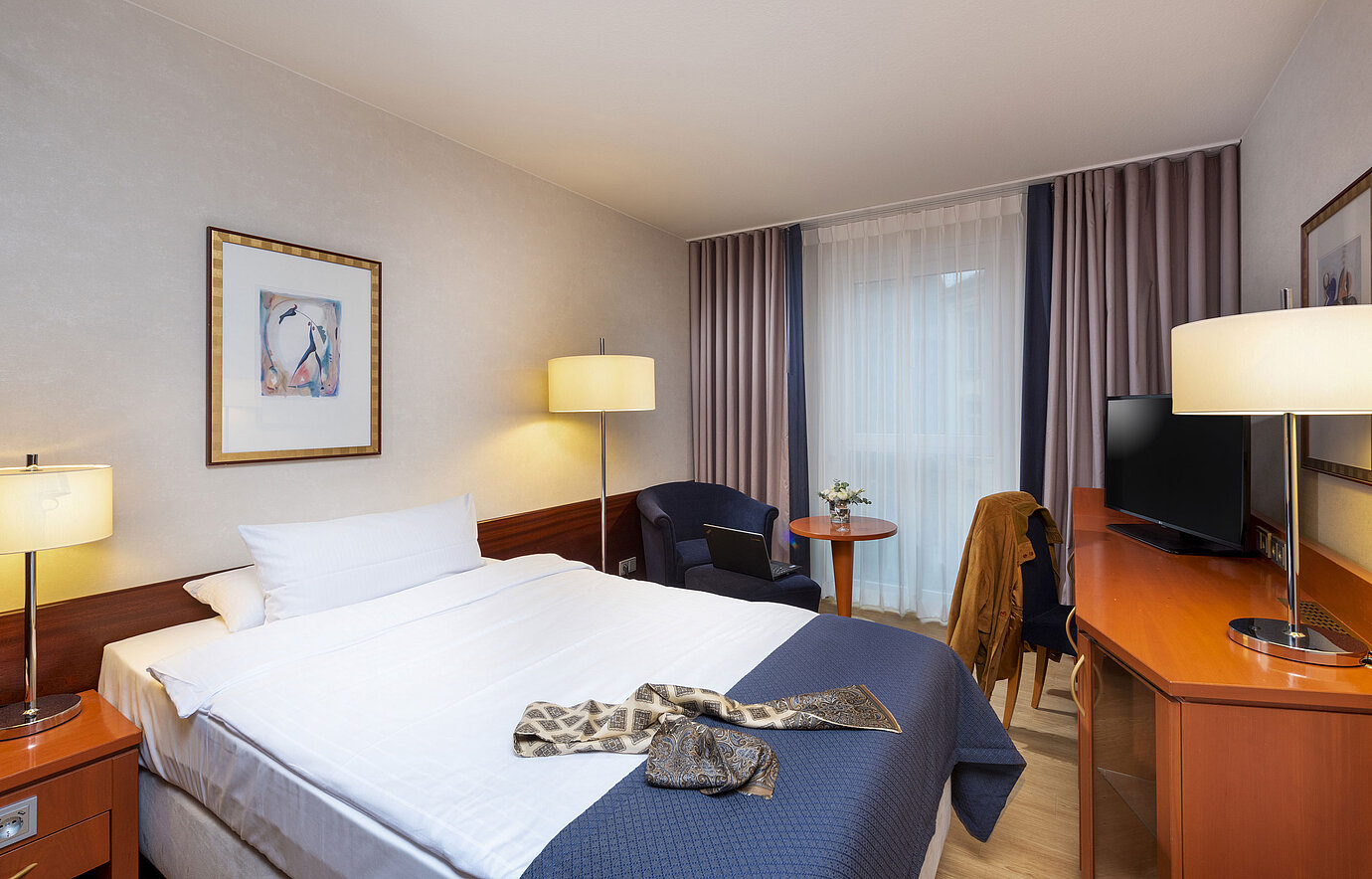 Helles Classic Einzelzimmer im Maritim Hotel Würzburg mit Sitzbereich und moderner Garderobe