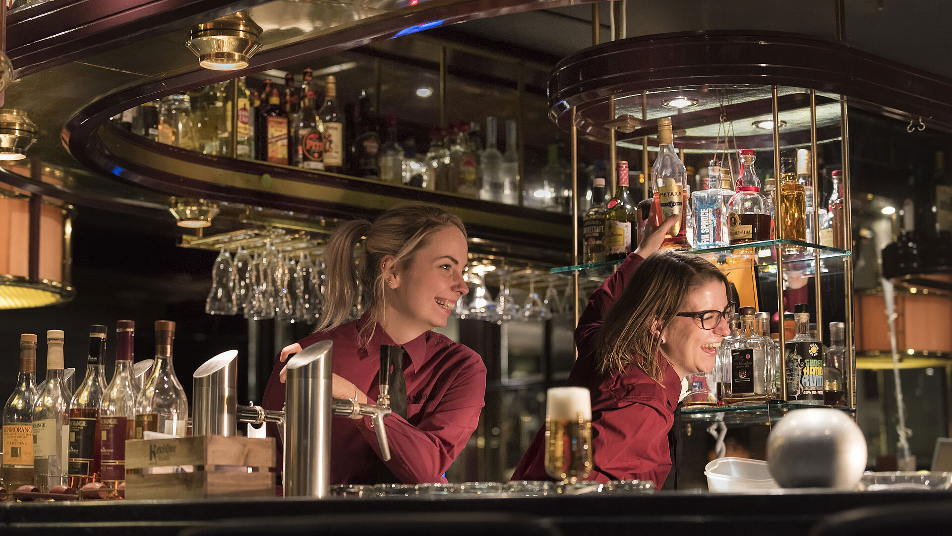 Pianobar Barkeeper in der Pianobar des Maritim Hotels Bonn, umgeben von einer großen Auswahl an Spirituosen und Getränken.