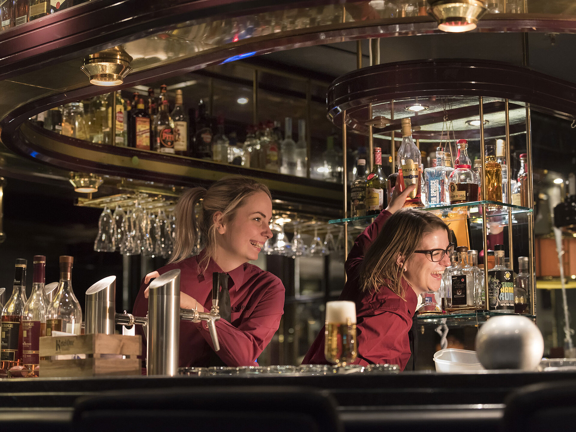 Pianobar Barkeeper in der Pianobar des Maritim Hotels Bonn, umgeben von einer großen Auswahl an Spirituosen und Getränken.