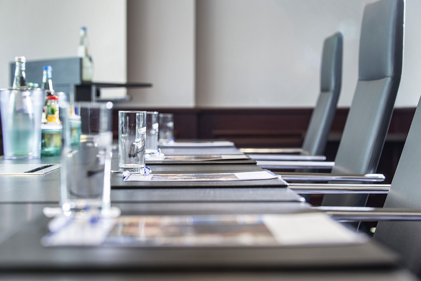 Nahaufnahme eines stilvoll gedeckten Konferenztischs mit Gläsern und Schreibunterlagen im Maritim Hotel Hannover.
