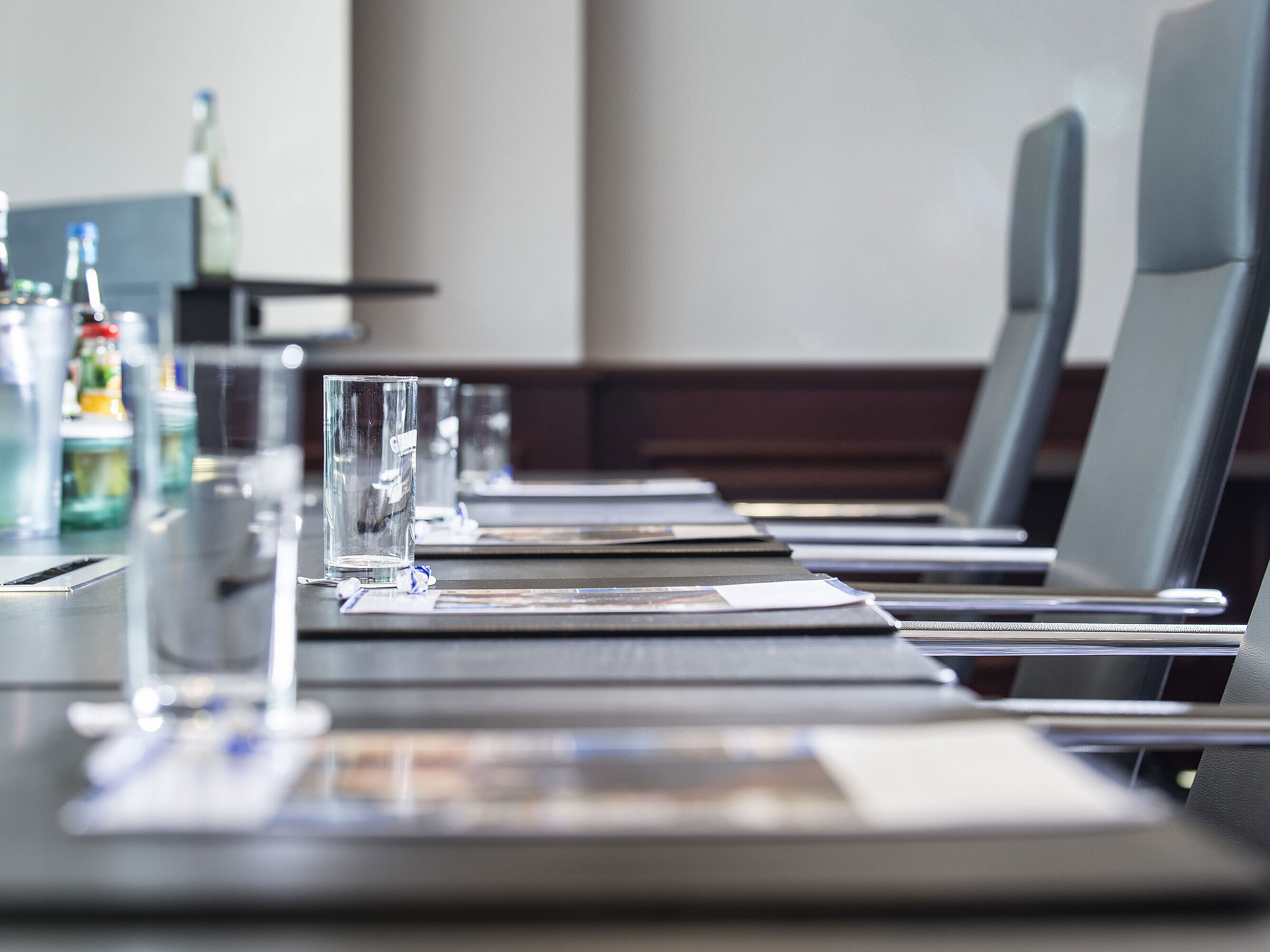 Nahaufnahme eines stilvoll gedeckten Konferenztischs mit Gläsern und Schreibunterlagen im Maritim Hotel Hannover.