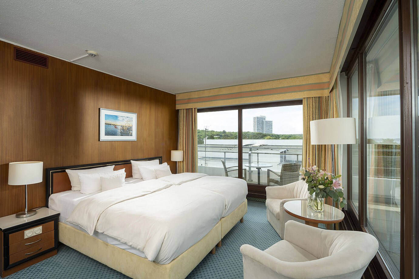 Geräumige Familiensuite im Maritim Seehotel Timmendorfer Strand mit Balkon, Meerblick und gemütlicher Sitzecke.