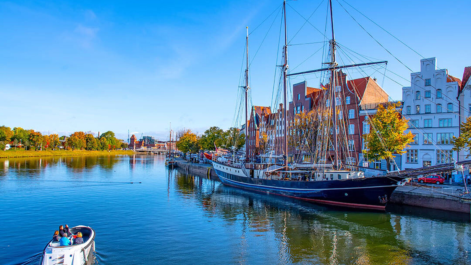 © Comofoto - Adobestock.com Segelschiff und Boote im Hafen der Altstadt Lübeck