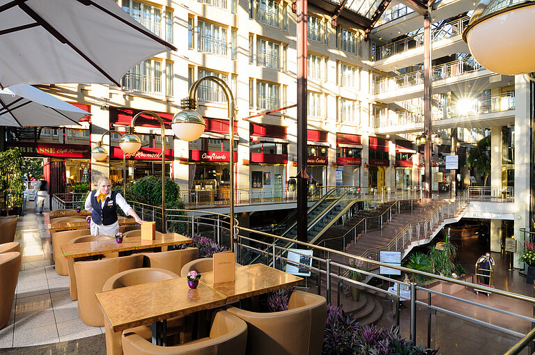 Café Heumarkt im Maritim Hotel Köln mit Sitzgelegenheiten und Servicepersonal in stilvoller Atmosphäre.
