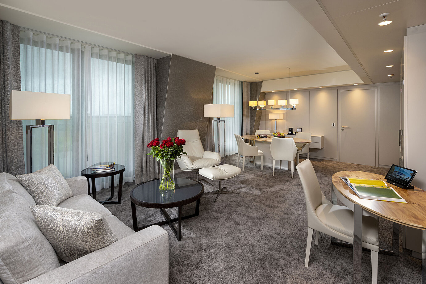 Hochwertig ausgestattete Suite mit stilvollem Interieur, Sitzbereich, Esstisch und eleganten Dekorationselementen.