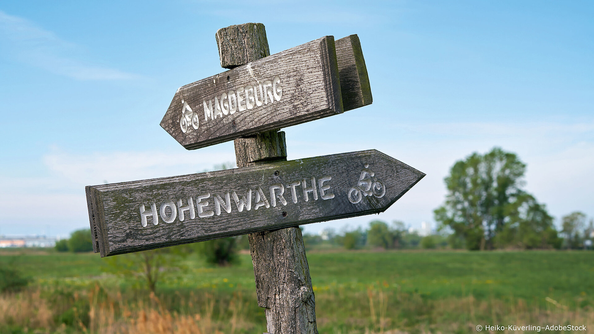Holzschild mit Wegweiser in der Natur urlaub-fahrradreise-routen