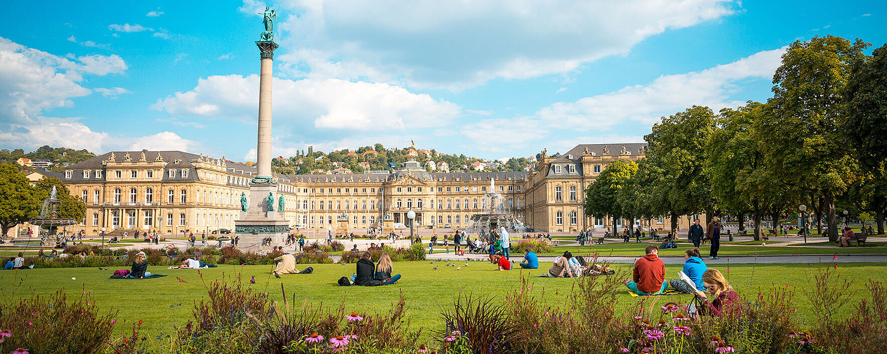 Schlossplatz Stuttgart mit Neuem Schloss, Jubiläumssäule, Blumenbeeten und grüner Parkanlage