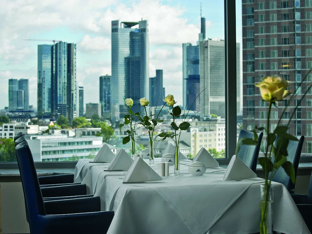 Eleganter Speiseraum mit Skyline-Blick und gedecktem Tisch in der SkyLounge im Maritim Hotel Frankfurt.